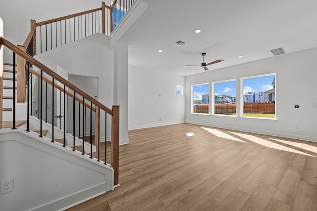 unfurnished living room featuring light hardwood / wood-style flooring and ceiling fan