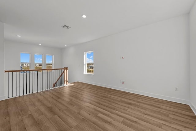 spare room featuring light hardwood / wood-style flooring and a healthy amount of sunlight