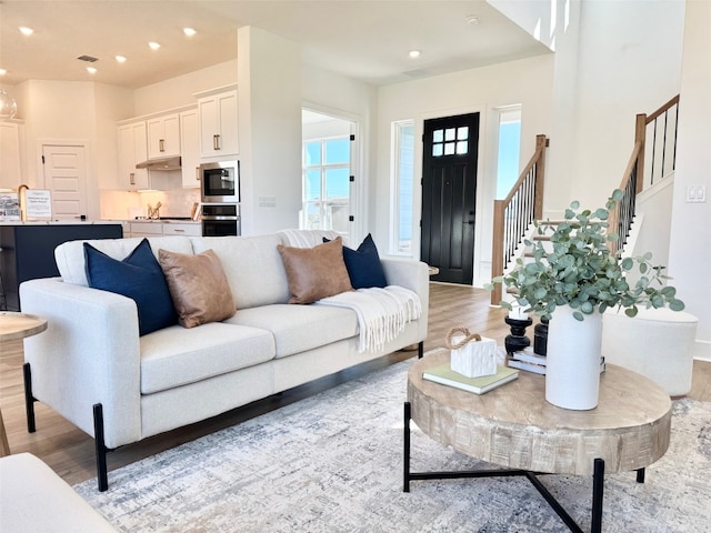 living room with light wood finished floors, stairway, recessed lighting, and visible vents