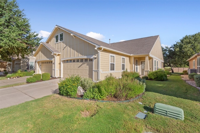 view of front of property featuring a garage, central AC, and a front lawn