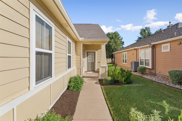 property entrance with cooling unit and a yard