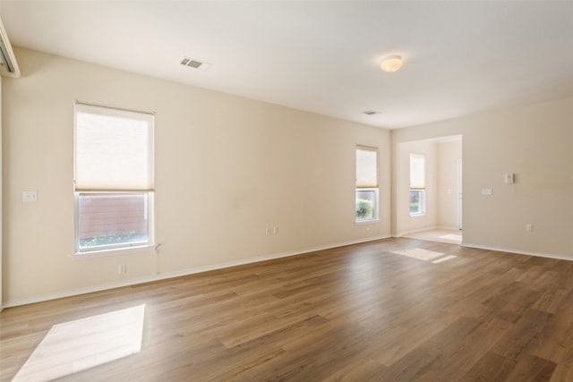 spare room featuring light wood-type flooring and a healthy amount of sunlight