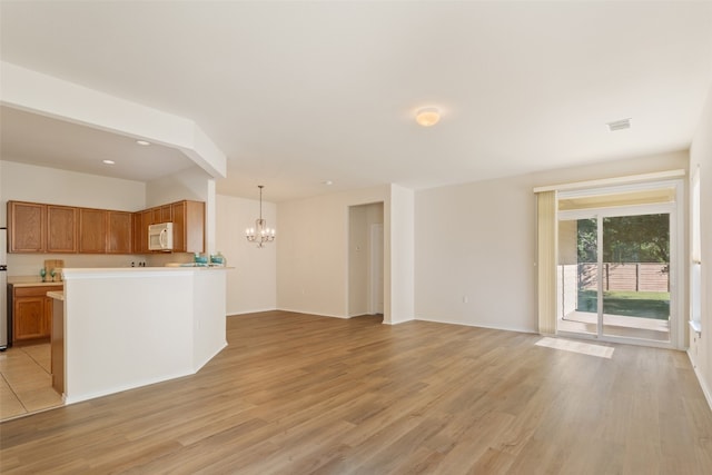 unfurnished living room with light hardwood / wood-style floors and an inviting chandelier