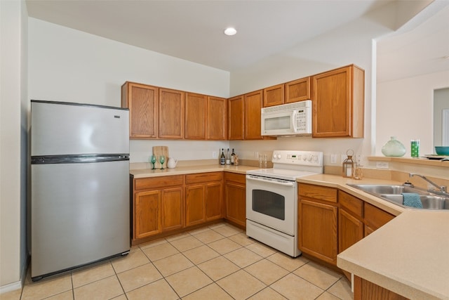 kitchen featuring sink, white appliances, and light tile patterned floors