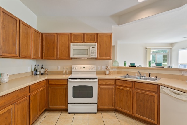 kitchen featuring sink, white appliances, light tile patterned flooring, and kitchen peninsula