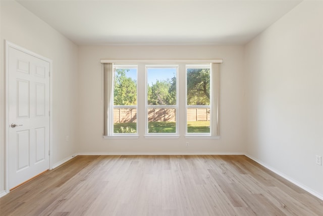 unfurnished room featuring light wood-type flooring and a healthy amount of sunlight