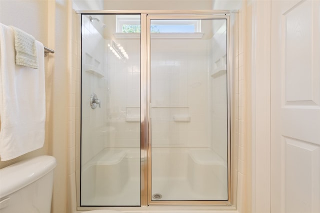 bathroom featuring an enclosed shower and toilet