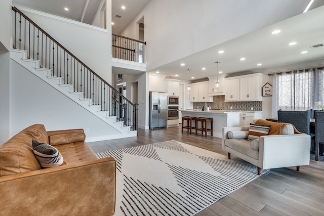 living room with high vaulted ceiling and dark hardwood / wood-style floors