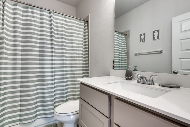 bathroom with toilet, vanity, and curtained shower