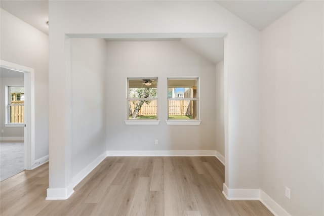 unfurnished room with vaulted ceiling and light hardwood / wood-style flooring