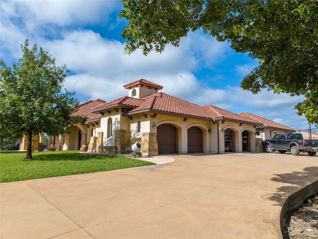 mediterranean / spanish home with a garage and a front yard