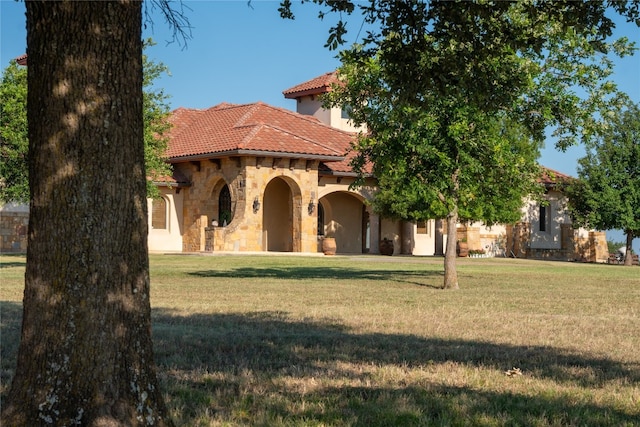 mediterranean / spanish home featuring a front lawn