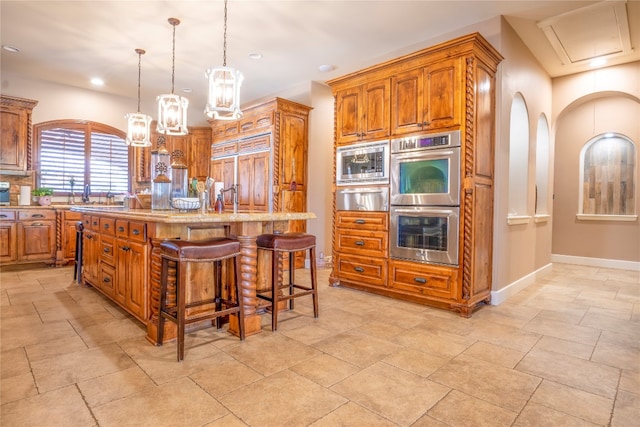 kitchen featuring light tile patterned floors, a kitchen bar, appliances with stainless steel finishes, and a kitchen island