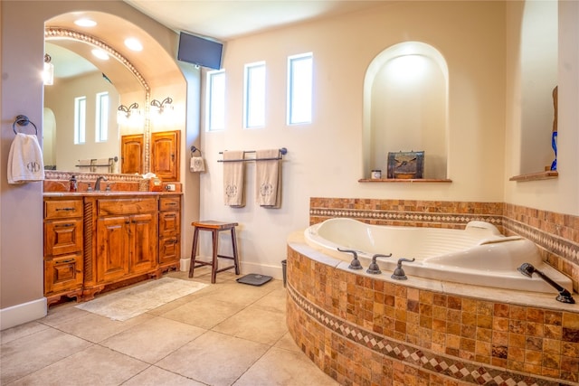 bathroom featuring tile patterned floors, plenty of natural light, vanity, and a relaxing tiled tub