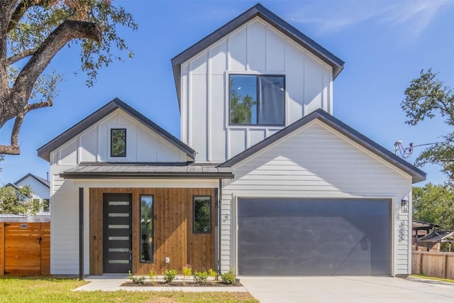 view of front facade featuring driveway, a standing seam roof, and board and batten siding