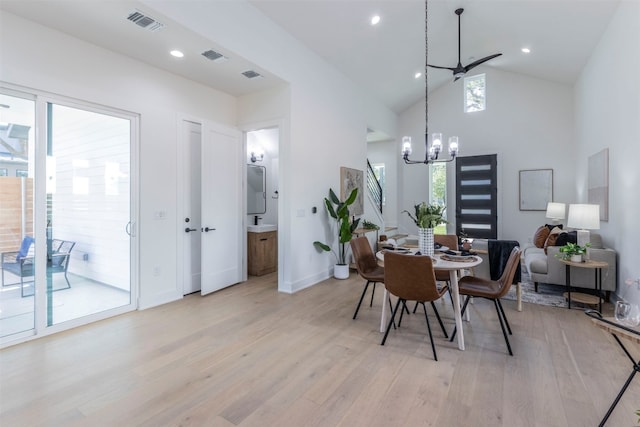 dining room featuring high vaulted ceiling, light hardwood / wood-style floors, and a chandelier