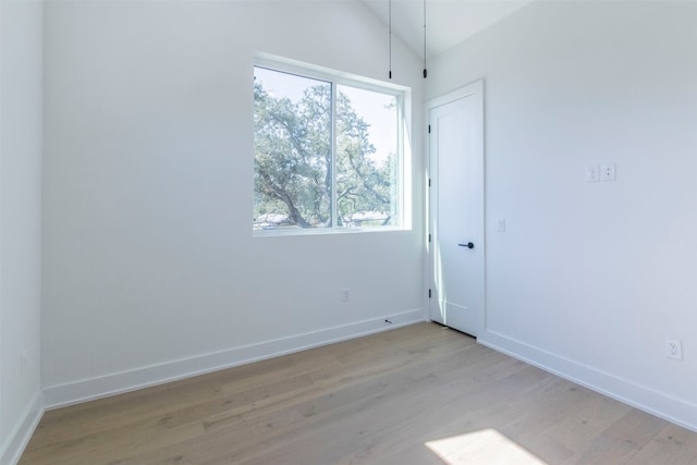 unfurnished room featuring a wealth of natural light, light hardwood / wood-style flooring, and lofted ceiling