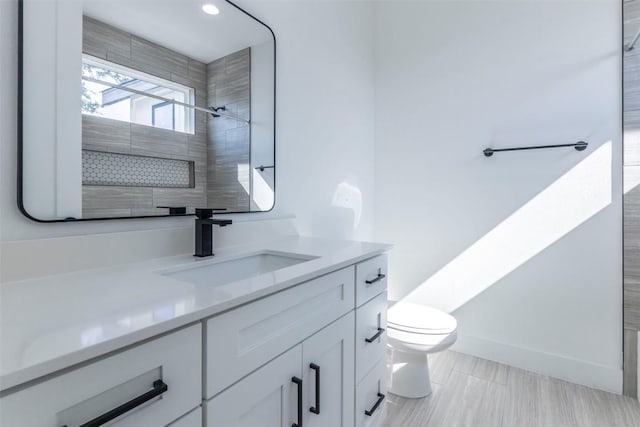 full bath with vanity, toilet, and baseboards