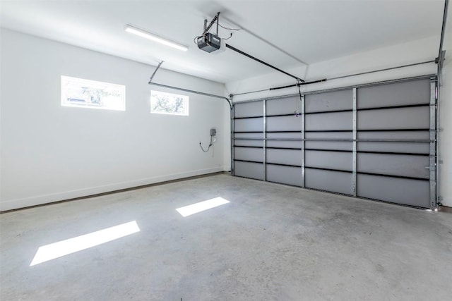 garage with a garage door opener and baseboards