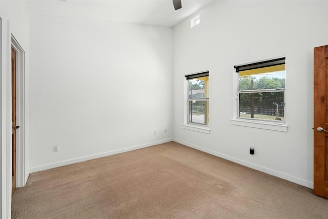 spare room featuring light carpet, visible vents, baseboards, and a ceiling fan