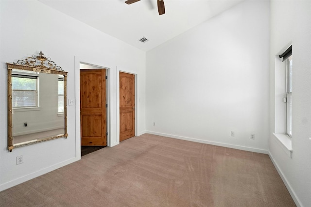 unfurnished bedroom with visible vents, baseboards, ceiling fan, carpet, and vaulted ceiling