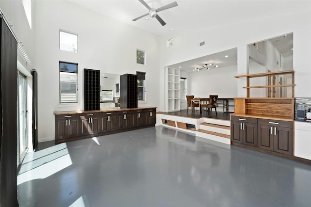 interior space with finished concrete flooring, visible vents, high vaulted ceiling, and a ceiling fan