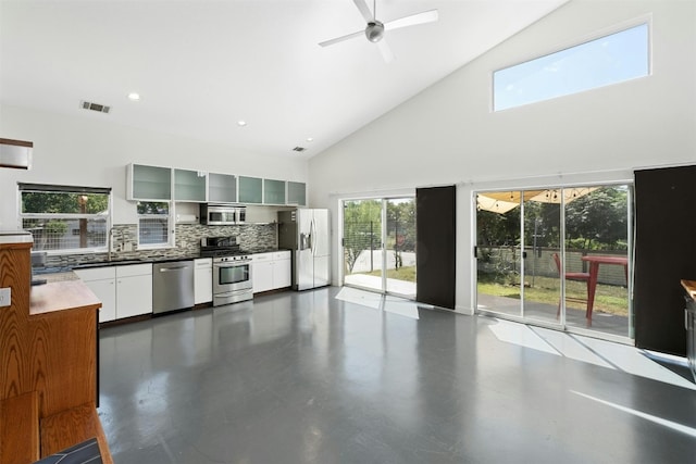 kitchen with stainless steel appliances, visible vents, backsplash, ceiling fan, and high vaulted ceiling