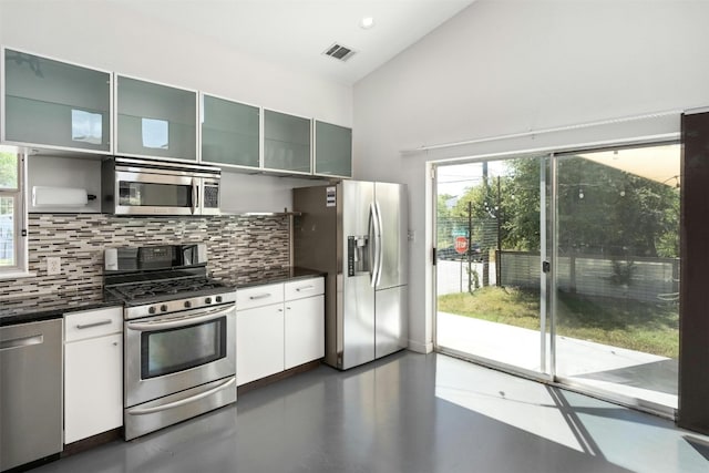 kitchen featuring stainless steel appliances, finished concrete floors, visible vents, and decorative backsplash