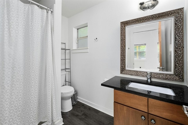 bathroom with baseboards, toilet, a shower with curtain, wood finished floors, and vanity