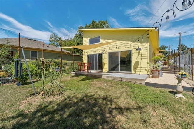 rear view of house with a yard, a patio area, and fence