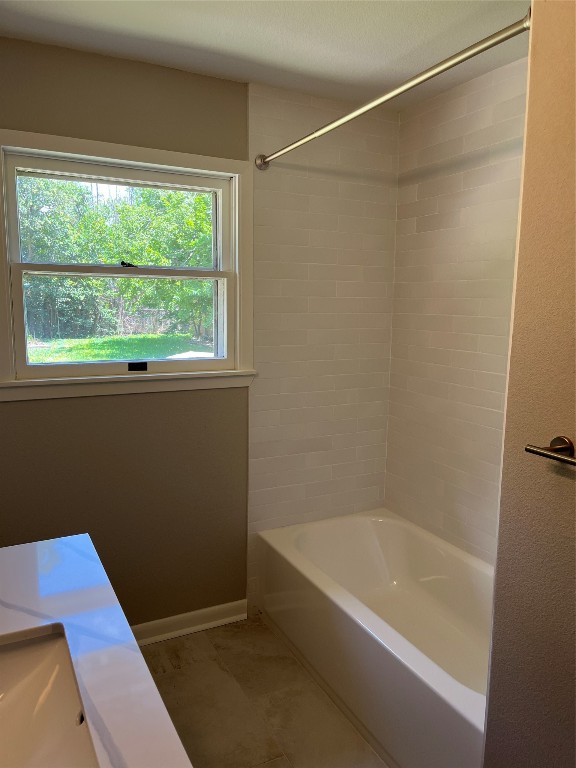 bathroom featuring tiled shower / bath combo and a healthy amount of sunlight