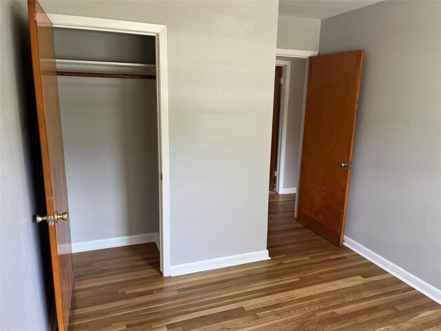 unfurnished bedroom featuring a closet and hardwood / wood-style floors