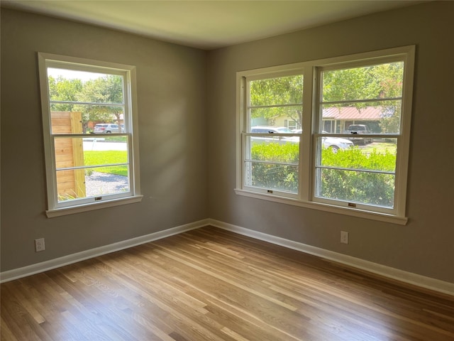 empty room featuring hardwood / wood-style floors and a healthy amount of sunlight