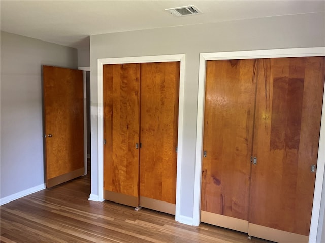 unfurnished bedroom with a closet and hardwood / wood-style floors