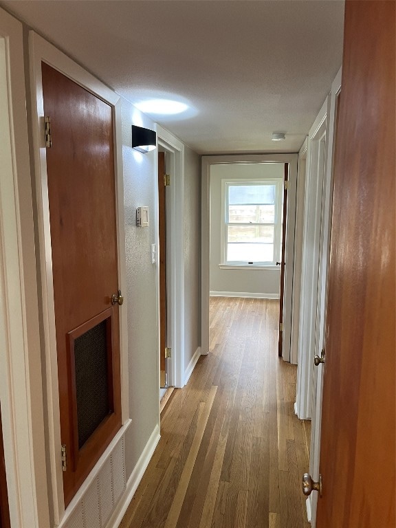 hallway with hardwood / wood-style floors