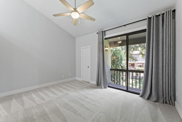 spare room featuring light colored carpet, vaulted ceiling, and ceiling fan