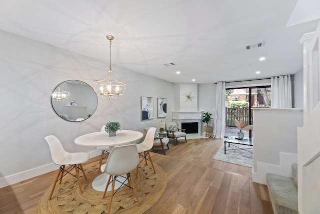 dining space with an inviting chandelier and light hardwood / wood-style floors