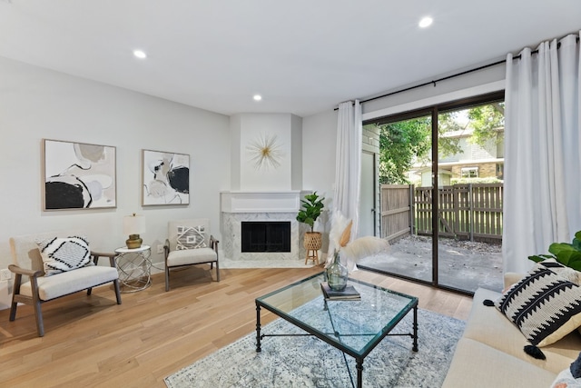 living room with light wood finished floors, a high end fireplace, and recessed lighting