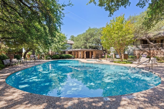 community pool featuring a patio and fence