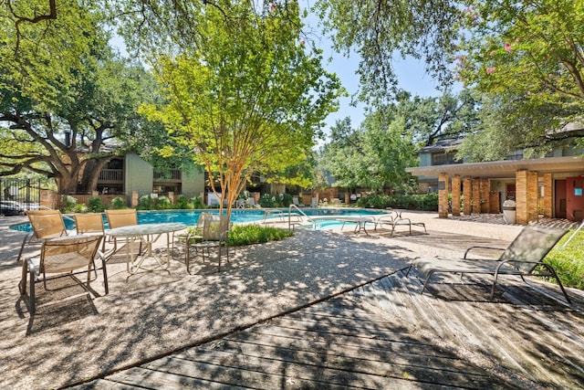 community pool with a patio area and fence