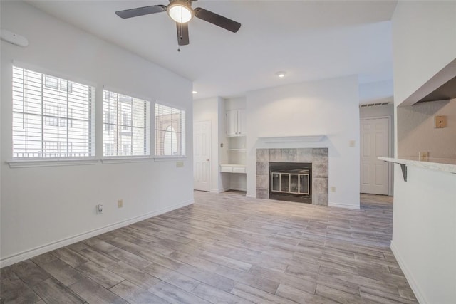 3001 Cedar St Unit A-116, Austin, TX 78705 - unfurnished living room featuring ceiling fan, light wood finished floors, a tiled fireplace, and recessed lighting