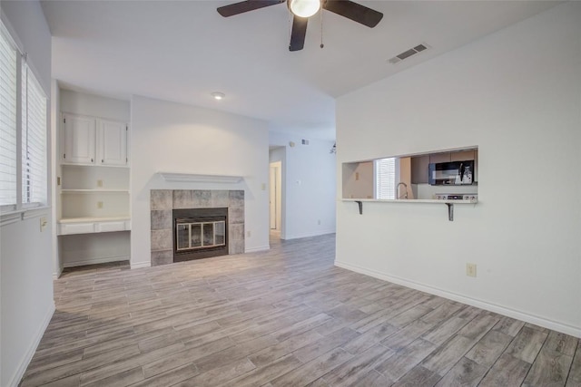 3001 Cedar St Unit A-116, Austin, TX 78705 - unfurnished living room with ceiling fan, light wood-style floors, and a fireplace