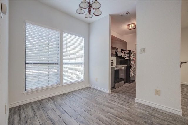 3001 Cedar St Unit A-116, Austin, TX 78705 - spare room with a chandelier and wood finished floors