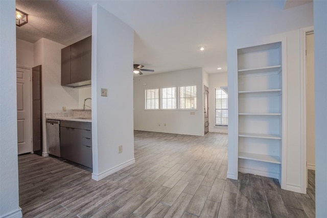 3001 Cedar St Unit A-116, Austin, TX 78705 - kitchen featuring ceiling fan, stainless steel dishwasher, dark wood-style floors, light countertops, and dark brown cabinets