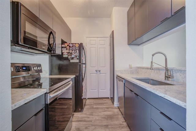 3001 Cedar St Unit A-116, Austin, TX 78705 - kitchen with stainless steel appliances, light wood finished floors, light stone countertops, and modern cabinets