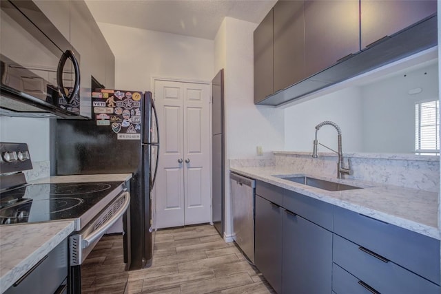 3001 Cedar St Unit A-116, Austin, TX 78705 - kitchen with black microwave, electric range oven, dishwasher, light wood-style flooring, and light stone counters