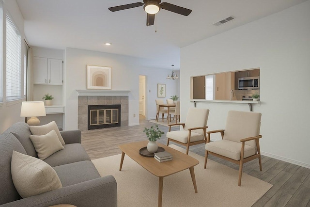3001 Cedar St Unit A-116, Austin, TX 78705 - living area featuring light wood-style floors, a ceiling fan, recessed lighting, a chandelier, and a tile fireplace