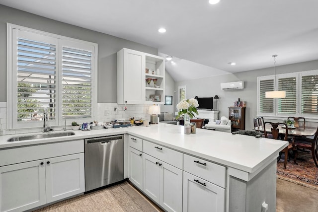 kitchen with a wall unit AC, pendant lighting, dishwasher, sink, and kitchen peninsula