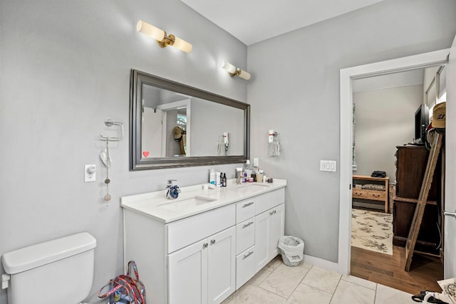 bathroom with hardwood / wood-style flooring, toilet, and dual bowl vanity