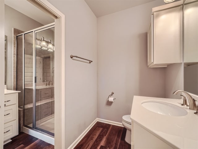 bathroom with hardwood / wood-style floors, vanity, toilet, and an enclosed shower